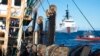 FILE - In this photo made available by the U.S. Coast Guard, guardsmen from the cutter James, seen at background right, conduct a boarding of a fishing vessel in the eastern Pacific Ocean, on Aug. 4, 2022. 