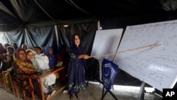 FILE - Flood affected children attend school organized by Islamic group Jamaat-e-Islami Pakistan, in Sukkur, Pakistan, Sept. 4, 2022. 