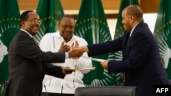 Redwan Hussien Rameto (L), Representative of the Ethiopian government, and Getachew Reda (R), Representative of the Tigray People's Liberation Front (TPLF), shake hands on a peace agreement on November 2, 2022. (Photo by PHILL MAGAKOE / AFP)