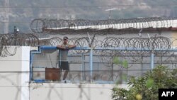 An inmate stands on the roof of the Litoral Penitentiary in Guayaquil, Ecuador, on Nov. 2, 2022. Police and soldiers on Wednesday patrolled the terror-stricken streets of two Ecuadorian cities after a spate of attacks blamed on organized crime groups waging a deadly drug war.
