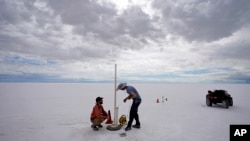 State biologists collects water samples in the Bonneville Salt Flats Tuesday, Sept. 13, 2022, near Wendover, Utah. The glistening white salt of the world famous area is shrinking near the Utah-Nevada line. (AP Photo/Rick Bowmer)