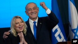 Former Israeli Prime Minister and the head of Likud party Benjamin Netanyahu and his wife, Sara, celebrate after first exit poll results for the Israeli Parliamentary election at his party's headquarters in Jerusalem, Nov. 2, 2022.