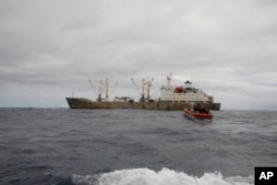 FILE - In this photo made available by the U.S. Coast Guard, guardsmen from the cutter James conduct a boarding of a fishing vessel in the eastern Pacific Ocean, on Aug. 3, 2022.