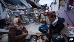 ครอบครัวในกาซ่าหุงหาอาหารหลังการถือศีลอด ท่ามกลางซากปรักหักพังในเมืองราฟาห์ ฉนวนกาซ่า เมื่อวันที่ 18 มีนาคม 2024 (เอพี) 