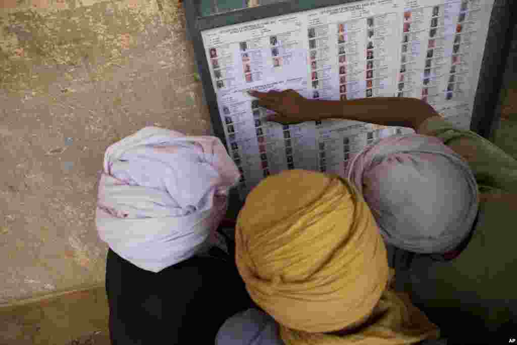 Men search for their names on a list of registered voters outside a polling station in Kidal, Mali, shortly after the opening of polls, July 28, 2013.&nbsp;
