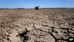 FILE - Exposed ground is seen in a dried-up riverbed where the normally wide Mississippi River would flow, Oct. 20, 2022, near Portageville, Missouri. The lack of rain in recent weeks has left the river approaching record-low levels in areas from Missouri south through Louisiana.