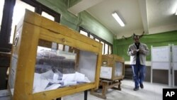 A man prepares to cast his vote during the second day of the parliamentary runoff elections at a polling station in Cairo, December 6, 2011.