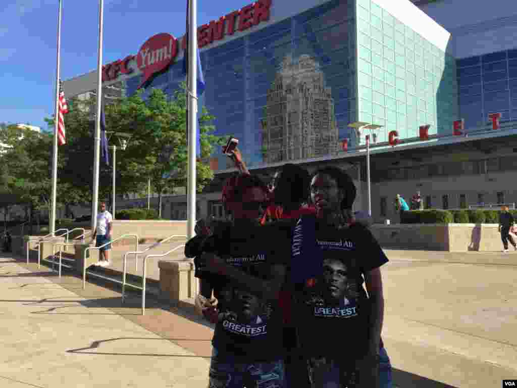 Teenagers pose for a photograph outside KFC Yum Center in Louisville, Kentucky, where the funeral of boxing great Muhammad Ali will be held Friday, June 10, 2016. (Photo: S. Ameen/VOA)