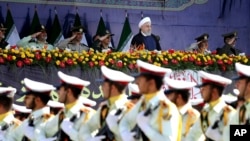 Presiden Iran Hassan Rouhani, atas tengah, menyaksikan pasukan militer berparade pada peringatan 38 tahun invasi Irak terhadap Iran, di depan makam pemimpin revolusioner, Ayatollah Khomeini, di luar Teheran, Iran, 22 September 2018.