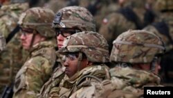 FILE - U.S. soldiers attend a welcoming ceremony for U.S.-led NATO troops at a military training site near Orzysz, Poland, April 13, 2017. 