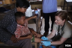 មន្ត្រី​កងទ័ពអាកាសសហរដ្ឋអាមេរិកព្យាបាលជើងដំបៅរបស់កុមារាមួយរូបនៅស្រុកកំពង់ត្រាច ខេត្តកំពត កាលពីថ្ងៃពុធ ទី១៥ ខែមិថុនា ឆ្នាំ២០១៦។