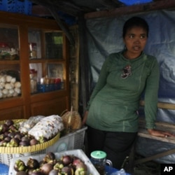 Jumilah lost five cattle from the volcanic eruption of Mount Merapi. She is slowly rebuilding her life by selling fruits at a roadside stall.