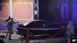 Seorang polisi memeriksa mobil yang menabrak gerbang kedutaan besar China di Buenos Aires, Argentina, Senin, 22 Juni 2020. (Foto AP / Natacha Pisarenko)