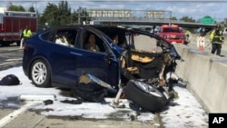 In this Friday March 23, 2018 photo provided by KTVU, emergency personnel work a the scene where a Tesla electric SUV crashed into a barrier on U.S. Highway 101 in Mountain View, Calif. (KTVU via AP)