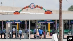 Para pengunjung memasuki pintu masuk "Magic Kingdom" salah satu taman hiburan Walt Disney World, saat pembukaan kembali di Lake Buena Vista, Florida, 11 Juli 2020. 