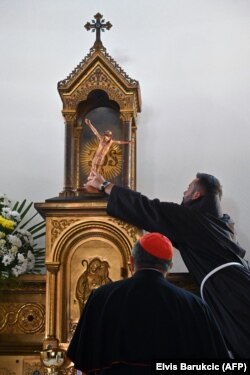 Seorang imam Fransiskan memasang patung Yesus di altar sebelum upacara pembukaan gereja Katolik yang baru dibangun di Bugojno, pada 2 Agustus 2022. (Foto: AFP/Elvis Barukcic)