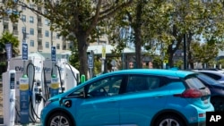 美国加尼福利亚州的环保标准最为严格。在加州街头和公路上以电力作为驱动能源的车随处可见。加州还规定到2035年时，禁止任何使用传统燃料，也就是石油中提取的汽油、柴油和煤油的车上路行驶。图为停在街头充电桩前充电的小轿车。-美联社资料照