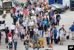Passengers are shown on the tarmac outside Fort Lauderdale–Hollywood International Airport, Friday, Jan. 6, 2017, in Fort Lauderdale, Florida, after a shooter opened fire inside a terminal of the airport, killing several people and wounding others before