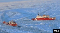 Kapal penjaga pantai AS Cutter Healy (kanan) memecah lapisan es di pantai Alaska agar kapal tanker Rusia bisa merapat ke pelabuhan kota Nome (13/2).
