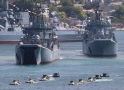 FILE - Russian armored personnel carriers submerge from amphibious assault ships during the Navy Day parade in the Black Sea port of Sevastopol, Crimea, July 26, 2020.