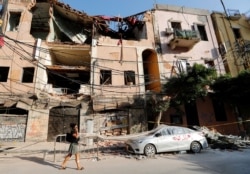 A woman walks past a damaged area in the aftermath of a massive explosion in Beirut, Lebanon, Aug. 13, 2020.