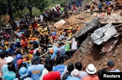 Rescuers search for people trapped in a landslide caused by Typhoon Mangkhut at a small-scale mining camp in Itogon, Benguet, in the Philippines, September 17, 2018.