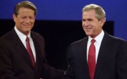 Capres AS dari Partai Demokrat Al Gore (kiri) dan Capres dari Partai Republik, George W. Bush berjabat tangan sebelum debat presiden pertama pada tahun 2000. (Foto: dok).