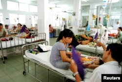 FILE - Vietnamese parents look after their children in a room designated for the treatment of dengue fever at Ho Chi Minh City's pediatric hospital, March 12, 2004.