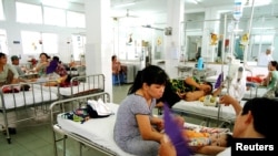 Vietnamese parents look after their children in a room designated for the treatment of dengue fever