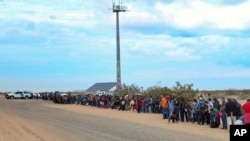 FILE - This Jan. 14, 2019, photo released by U.S. Customs and Border Protection shows some of the 376 Central Americans the Border Patrol says it arrested, the vast majority of them families who dug holes to cross into the United States, about 10 miles east of San Luis, Ariz. 