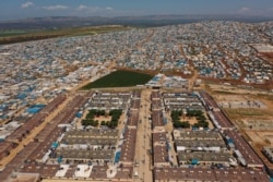 FILE - A refugee camp is seen on the Syrian side of the border with Turkey, near Atma, April 19, 2020.