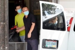 People remove bags from inside the Chinese Consulate to load into a van in Houston, July 23, 2020.