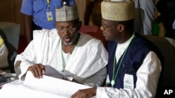 Ketua Komisi Pemilu Independen Nigeria, Attahiru Jega (kiri) memeriksa hail pummel di pusat koalisi di Abuja, Nigeria, 30 Maret 2015 (AP Photo/Sunday Alamba).