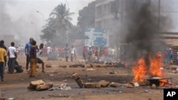 Anti government protesters burn tires and place rocks in the streets in Conakry, Guinea, May 3, 2013
