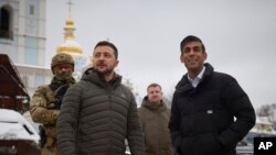 In this photo provided by the Ukrainian Presidential Press Office, Ukrainian President Volodymyr Zelenskyy, left, and British Prime Minister Rishi Sunak look at destroyed Russian military vehicles on display in downtown Kyiv, Ukraine, Nov. 19, 2022.