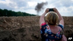 资料照片：一名记者正在拍摄乌克兰扫雷人员清除地雷的场景。（2022年6月9日）