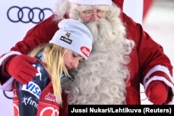 Mikaela Shiffrin of the U.S. celebrates after winning the women's slalom competition with Santa Claus during the FIS Ski World Cup in Levi, Finland, Nov. 20, 2022.