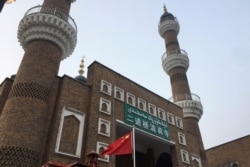 FILE - The Chinese national flag flies outside the mosque at the Xinjiang International Grand Bazar in Urumqi, Xinjiang Uighur Autonomous Region, China, Jan. 3, 2019.