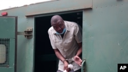 FILE - Zimbabwe journalist Hopewell Chin’ono gets out of a prison van at the magistrates courts in Harare, Nov. 6, 2020.
