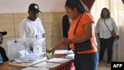 A voter dips her finger in ink after casting her ballot at the Nuestra Senior college polling station in Bisila, Malabo, during Equatorial Guinea's presidential, legislative and municipal elections, Nov. 20, 2022.