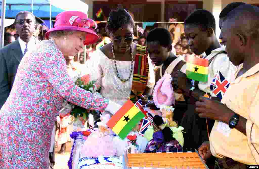 Britain&#39;s Queen Elizabeth II looks at a craft display presented by students at La Wireless school in Accra, on the second day of her state visit to Ghana November 8, 1999. The Queen accompanied by her husband [Prince Phillip] began a three nation African tour on Sunday.