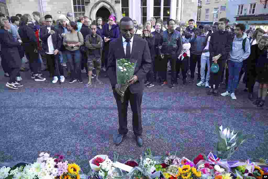 Mourners gather laying flowers outside Windsor Castle in Berkshire, England, Sept. 8, 2022, following the announcement of the death of Queen Elizabeth II. 