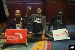 Florida state lawmakers protest at the state legislature during a debate about establishing new congressional districts, April 21, 2022, in Tallahassee.