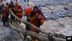 In this photo released by Xinhua News Agency, rescuers carry a villager across a river following an earthquake in Moxi Town of Luding County, southwest China's Sichuan Province on Monday, Sept. 5, 2022. (Cheng Xueli/Xinhua via AP)