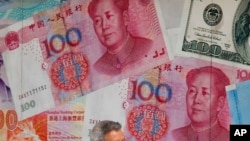 一百元面值的人民币和美元 。（美联社示意图）