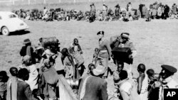 Members of the Lancashire Fusiliers, King's African Rifles, Kenya Police and Kenya Police Reserve and Government Officers, force the evacuation of Kikuyu men, women and children who are accused of squatting on European farms in Kenya on Nov. 30, 1952.