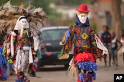 Gule Wamkulu dance secretive society members in gory masks and colorful outfits walk on the streets enroute to their ritual dance performance in Harare, Zimbabwe, Oct. 23, 2022.
