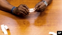 Harold Lewis, seorang pengguna narkoba yang sedang dalam pemulihan, menunjukkan secarik kertas untuk hadiah kecil, Senin, 18 Juli 2022 di Program Pembebasan di Bridgeport, Conn. ( APo/Julia Nikhinson)