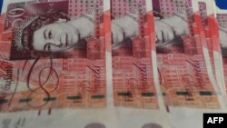 FILE - British pound notes are displayed at a money changer in Kuala Lumpur, Jan. 16, 2017. The face of the new King Charles III will soon begin to appear on British coins and banknotes.