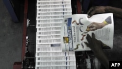 FILE - A technician inspects copies of the Chinese-owned newspaper, China Daily, at the printing press in Nairobi, Kenya, Jan. 3, 2013.